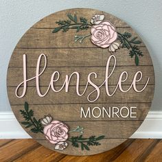 a wooden sign that says henslee monroe with pink flowers on the front and side