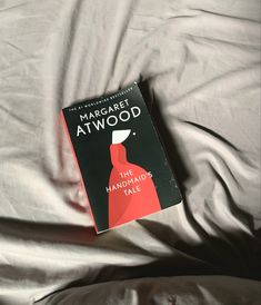 a book sitting on top of a bed next to a white comforter covered in sheets