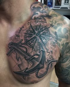 a man's chest with an anchor and compass tattoo on it