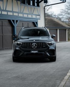 a black mercedes suv parked in front of a garage