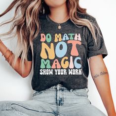 a woman wearing a t - shirt that says do math not magic show your work