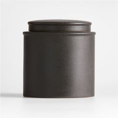 a black canister sitting on top of a white table