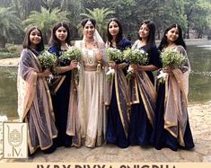 a group of women standing next to each other in front of a body of water