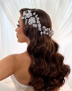 a woman wearing a bridal hair comb with flowers on it's head and shoulder