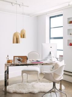 an office with white furniture and gold fixtures in the background, along with a large window