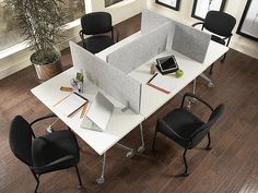 an office cubicle with chairs and desks is shown