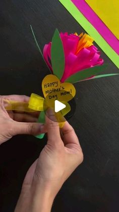 someone is holding up a paper flower with the words happy mother's day on it