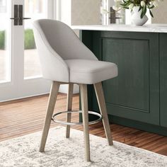 a white bar stool sitting on top of a wooden floor next to a kitchen counter