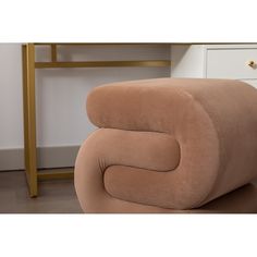 a brown chair sitting on top of a wooden floor next to a white dresser and table