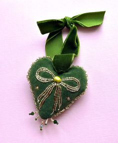 a green heart shaped ornament with a bow