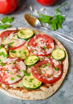 a pizza topped with cucumbers and tomatoes