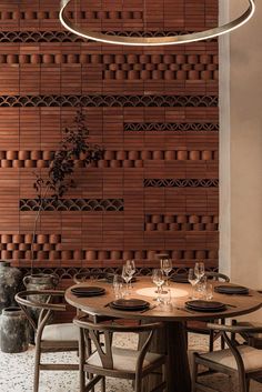 a dining room table with place settings and chairs in front of a wall made out of bricks