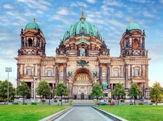 a large building with two towers and green domes