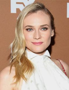 a woman with blonde hair wearing a white shirt and black skirt, posing for the camera