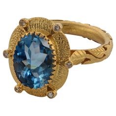 A striking one-of-a-kind blue topaz and diamond 18k gold cocktail ring. Handmade in our workshops, this ring features a 4.45 flawless blue topaz, which is flanked by six full cut diamonds set in exquisite hand-engraved 18k gold floral motifs. The ring dimensions are 20mm x 17mm. Sapphire Cocktail Ring, Diamond Gold Ring, Gold Cocktail Ring, Contemporary Ring, Gold Cocktail, 18k Gold Ring, Citrine Stone, Diamond Rings Bands, Diamond Gold