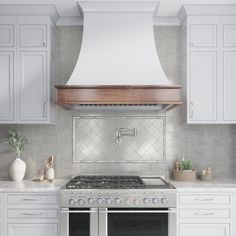 a stove top oven sitting inside of a kitchen next to white cabinets and counter tops