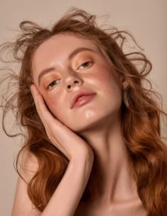 a woman with red hair and freckles on her face is posing for the camera