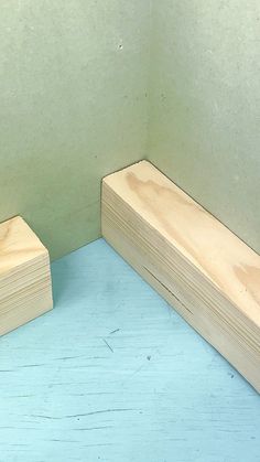 two pieces of wood sitting next to each other on a blue tablecloth covered floor