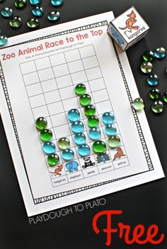 the zoo animal race to the top game is shown on a table with beads and paper