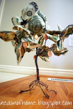 a tree made out of money sitting on top of a wooden table