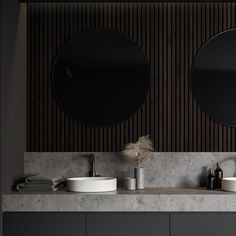 two round mirrors on the wall in a bathroom