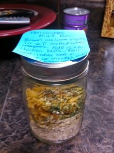 a jar filled with food sitting on top of a counter next to a blue note