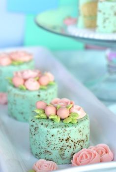 there are three cakes with flowers on the top one is green and has pink frosting