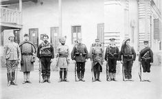 a group of men standing next to each other in front of a building