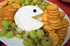 a plate with grapes, crackers and cheese on it