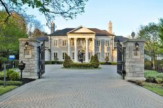 the entrance to a large mansion with pillars and columns on each side, surrounded by stone walls