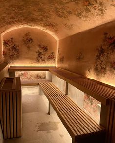 a wooden bench sitting in the middle of a room with floral wallpaper on it