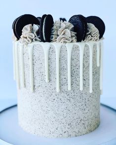 an oreo cookie cake with white frosting and cookies on top, drizzled with icing