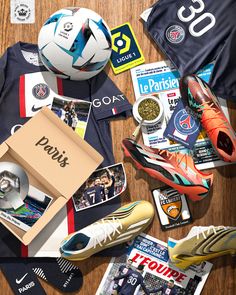 there are many different items on the table including shoes, soccer balls and other sports related items