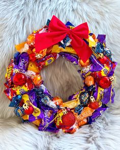 a wreath made out of candy is sitting on a furnishing with a red bow