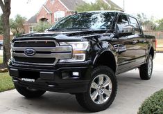 a black pickup truck parked in front of a house