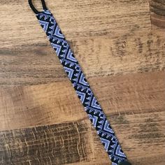 a blue and black lanyard on top of a wooden table