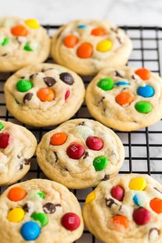 cookies with m & m's on top are cooling on a rack