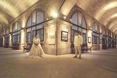 a man and woman standing next to each other in a train station