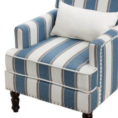 a blue and white striped chair with two pillows on top of the armrests