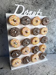 there are many doughnuts on the white board that is decorated with sprinkles