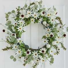 a wreath with white flowers and green leaves