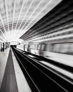 a black and white photo of a subway station