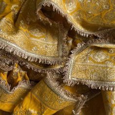 yellow and white fabric with fringes on the edges, in an old fashion style