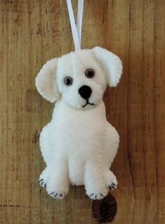 a white dog ornament hanging on a wooden wall