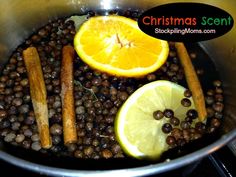 a pan filled with spices and lemons on top of a stove next to an orange slice