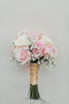 a bouquet of pink roses and baby's breath in a vase