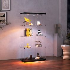 a glass shelf with books and vases on it