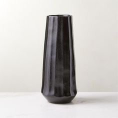 a black vase sitting on top of a white table