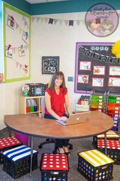 a woman sitting at a table with a laptop in front of her and several cubes on the floor