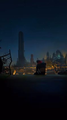 a man sitting on top of a bench in the dark with a city behind him